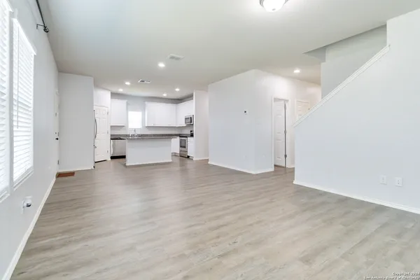 an empty room with wooden floor and a window