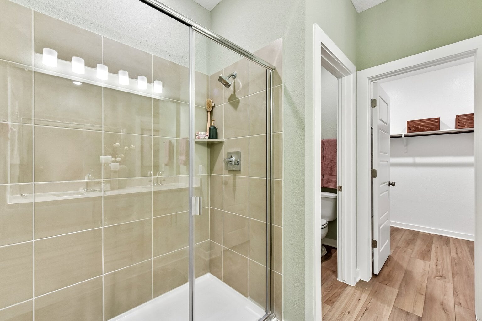 10609 Trifecta Way Buda, TX 78610 - Photo 7 of 17 A well-lit, tiled shower with a glass enclosure adjoins a spacious walk-in closet.