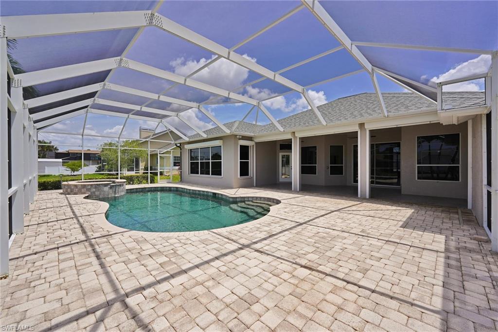 20620 Park Place Estero, FL 33928 - Photo 24 of 28 View of pool featuring a pool with connected hot tub, a patio, and glass enclosure