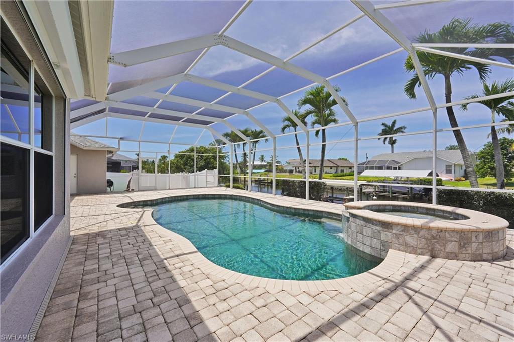 20620 Park Place Estero, FL 33928 - Photo 25 of 28 View of pool with a water view, glass enclosure, a patio, and a pool with connected hot tub