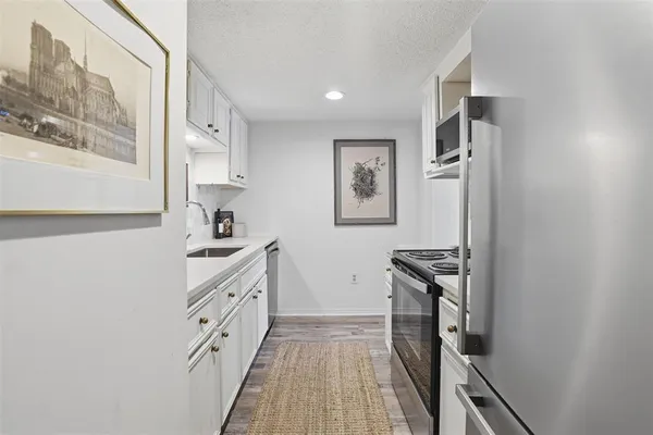 a kitchen with granite countertop a refrigerator and a stove