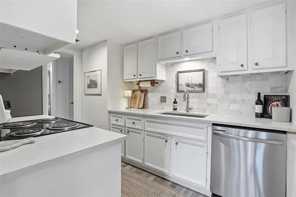 a kitchen with white cabinets and appliances