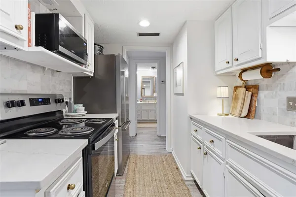 a kitchen with stainless steel appliances a stove a sink and a refrigerator