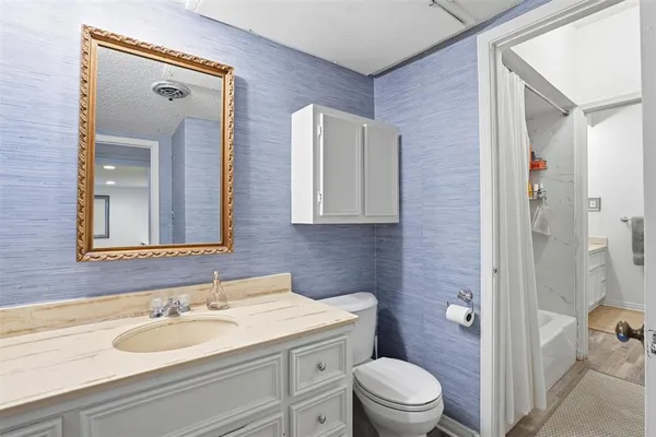 a bathroom with a granite countertop sink toilet a mirror a vanity and shower