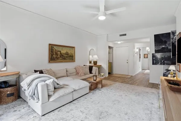 a living room with furniture a flat screen tv and a large window
