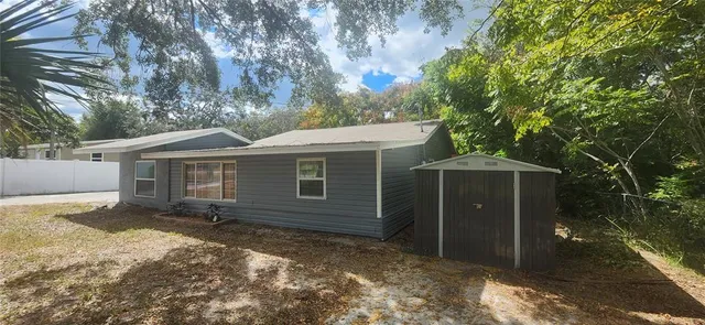 a view of a house with a yard and large tree