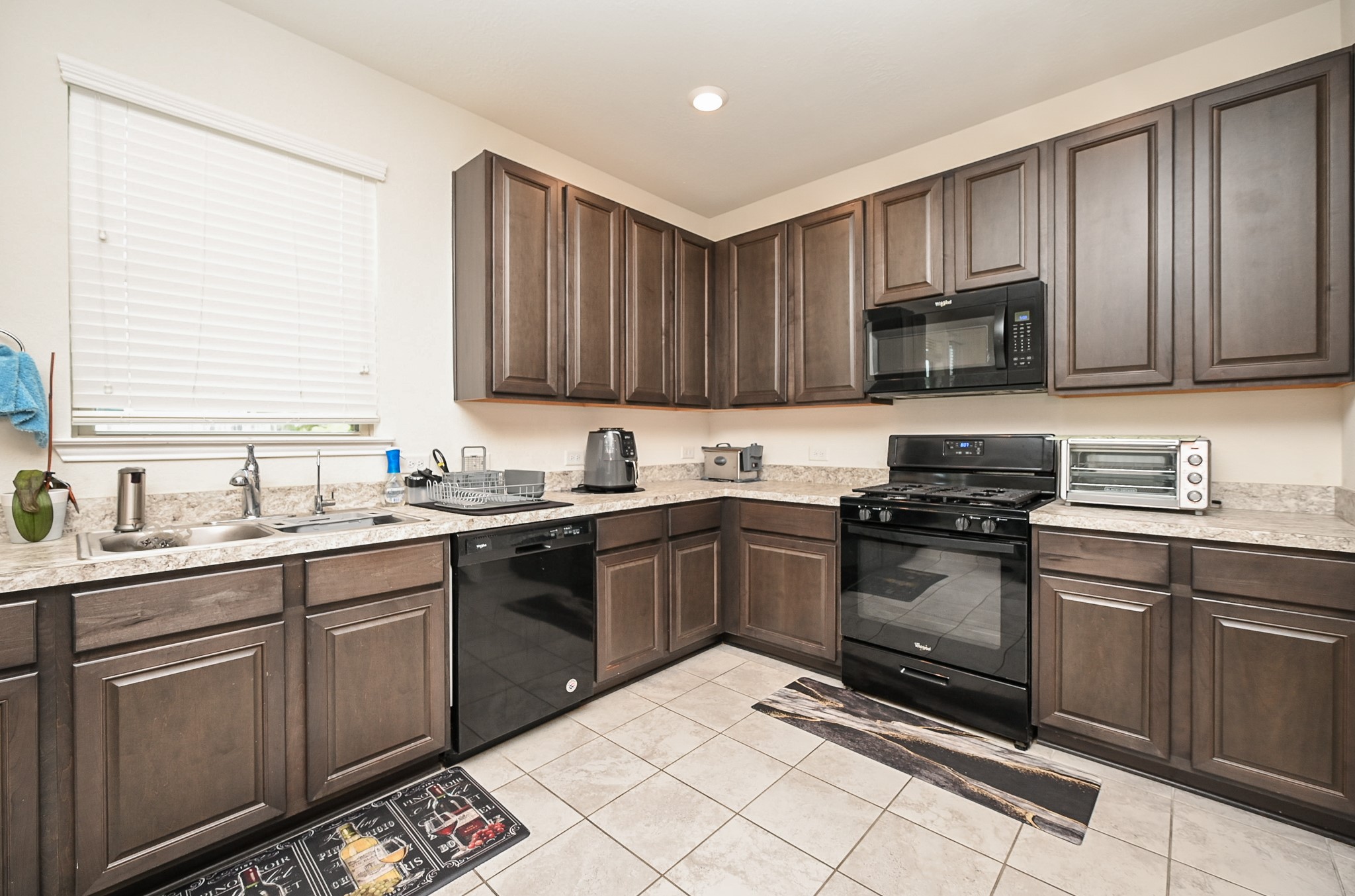 5238 Pine Forest Ridge Street Katy, TX 77493 - Photo 7 of 26 a kitchen with a sink stove and microwave
