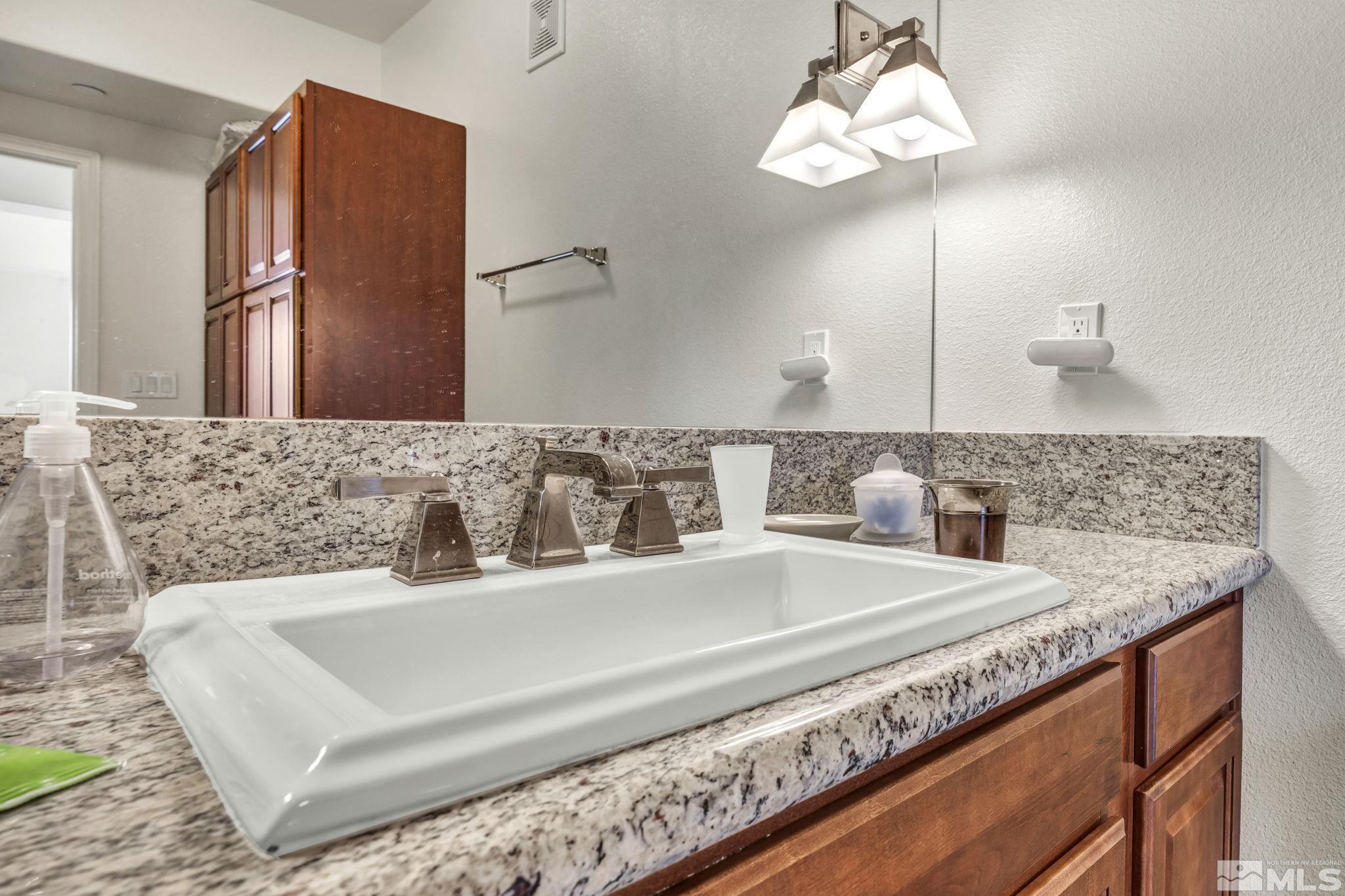 200 West 2nd Street, Unit 1207 Reno, NV 89501 - Photo 14 of 39 a bathroom with a granite countertop sink and a mirror