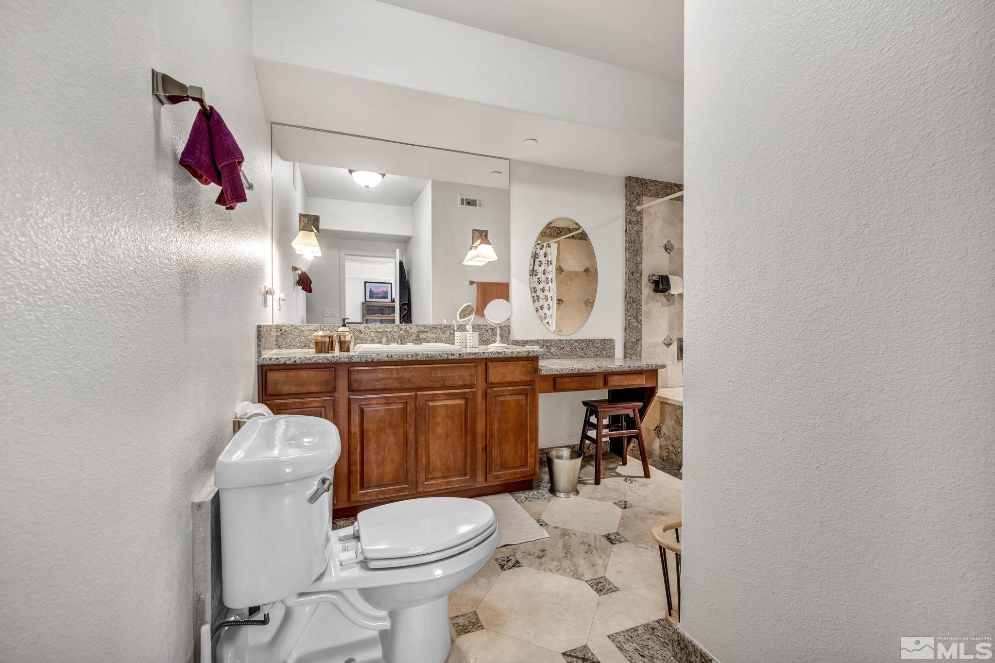 200 West 2nd Street, Unit 1207 Reno, NV 89501 - Photo 22 of 39 a bathroom with a toilet sink vanity granite and mirror