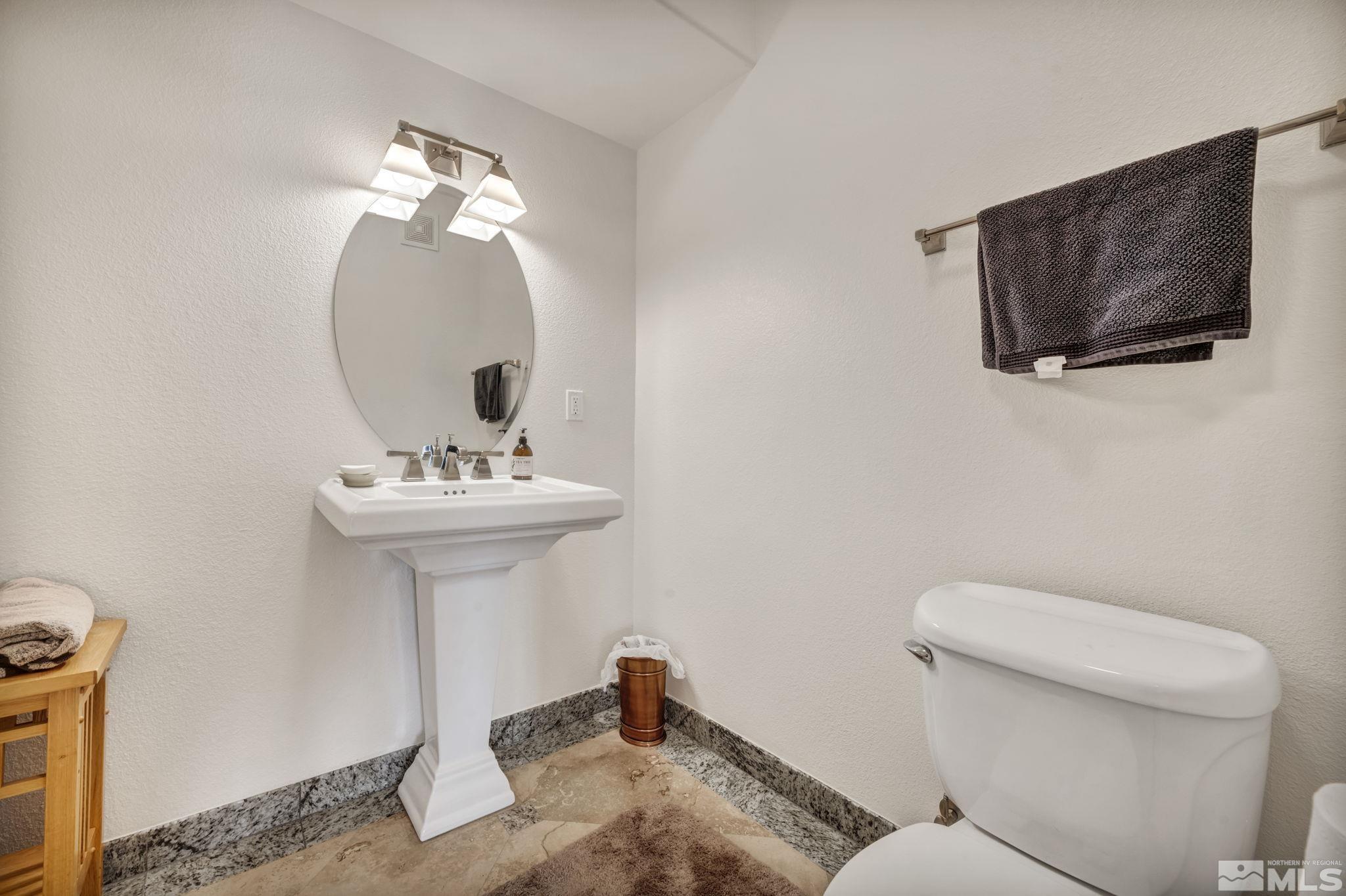 200 West 2nd Street, Unit 1207 Reno, NV 89501 - Photo 31 of 39 a bathroom with a sink a mirror and a toilet