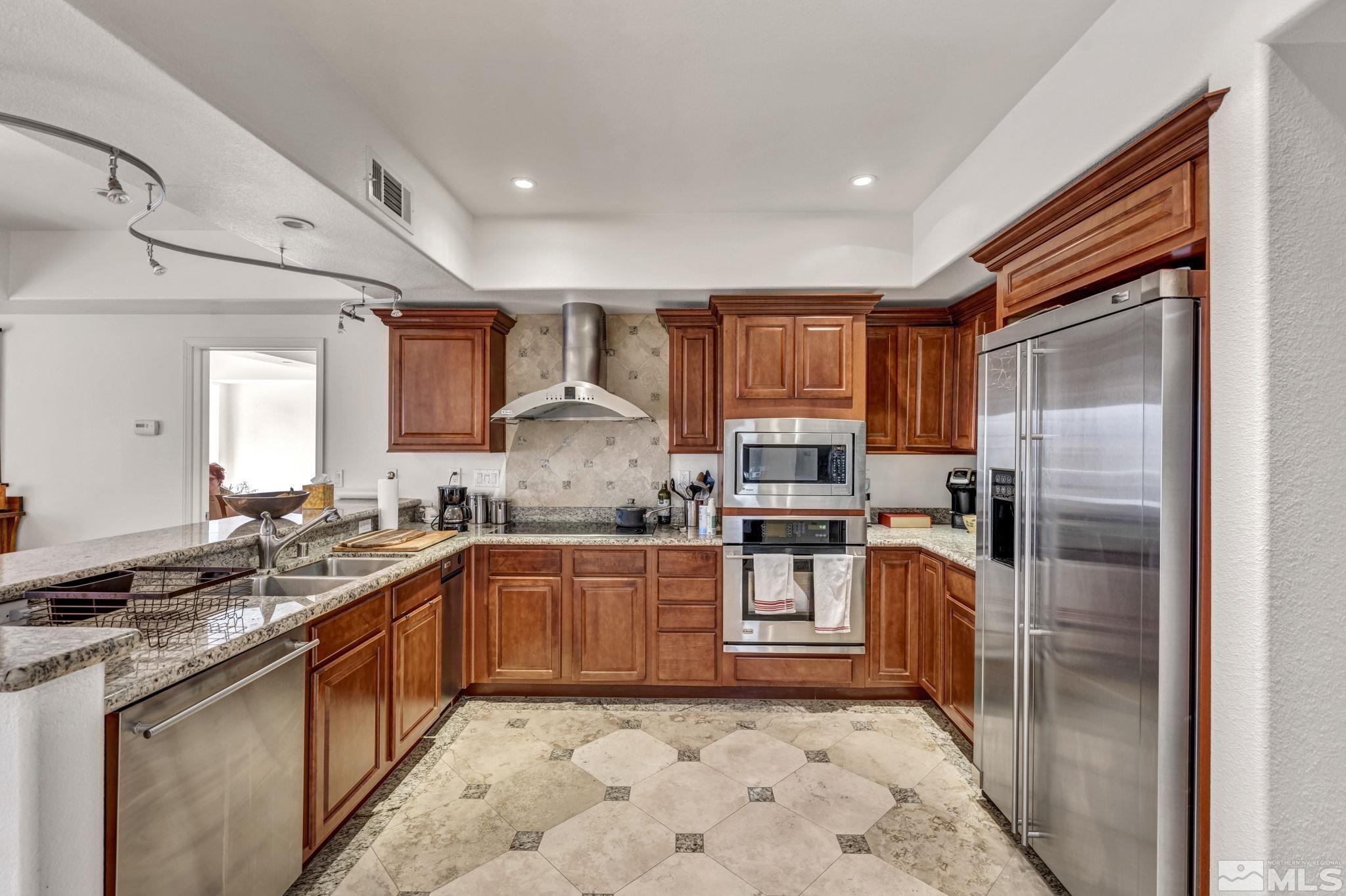 200 West 2nd Street, Unit 1207 Reno, NV 89501 - Photo 4 of 39 a kitchen with stainless steel appliances granite countertop a sink stove refrigerator and cabinets