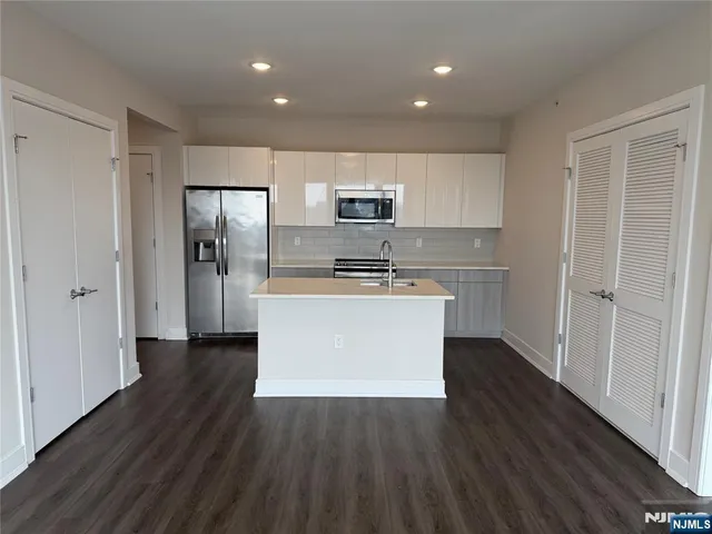 a view of kitchen with cabinets microwave and refrigerator