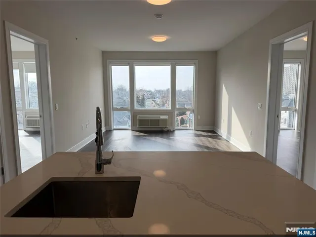 a view of kitchen with granite countertop a sink and a window