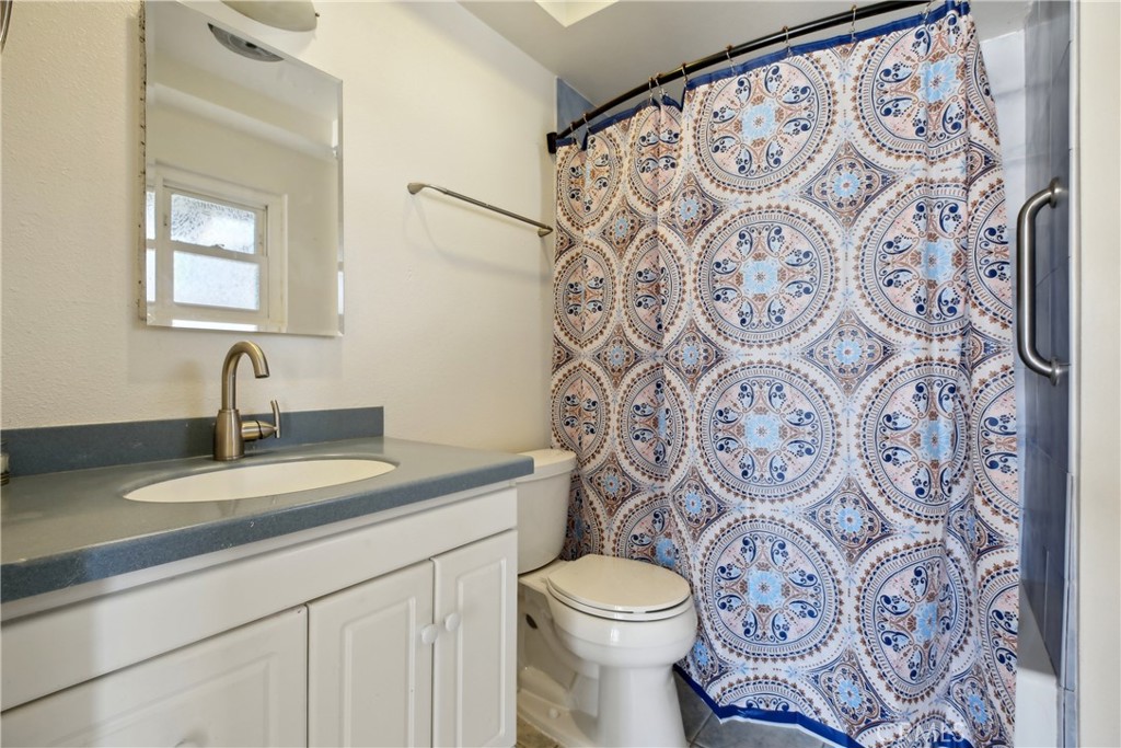 4018 Bryant Court Cypress, CA 90630 - Photo 15 of 16 a bathroom with a granite countertop toilet sink and mirror