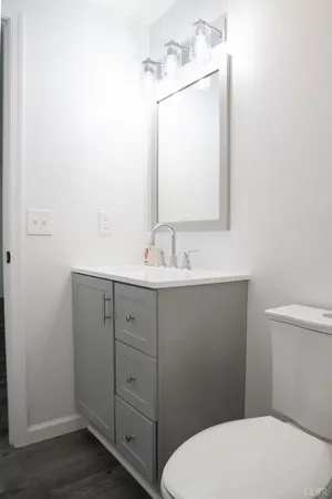 a bathroom with a toilet sink vanity and mirror
