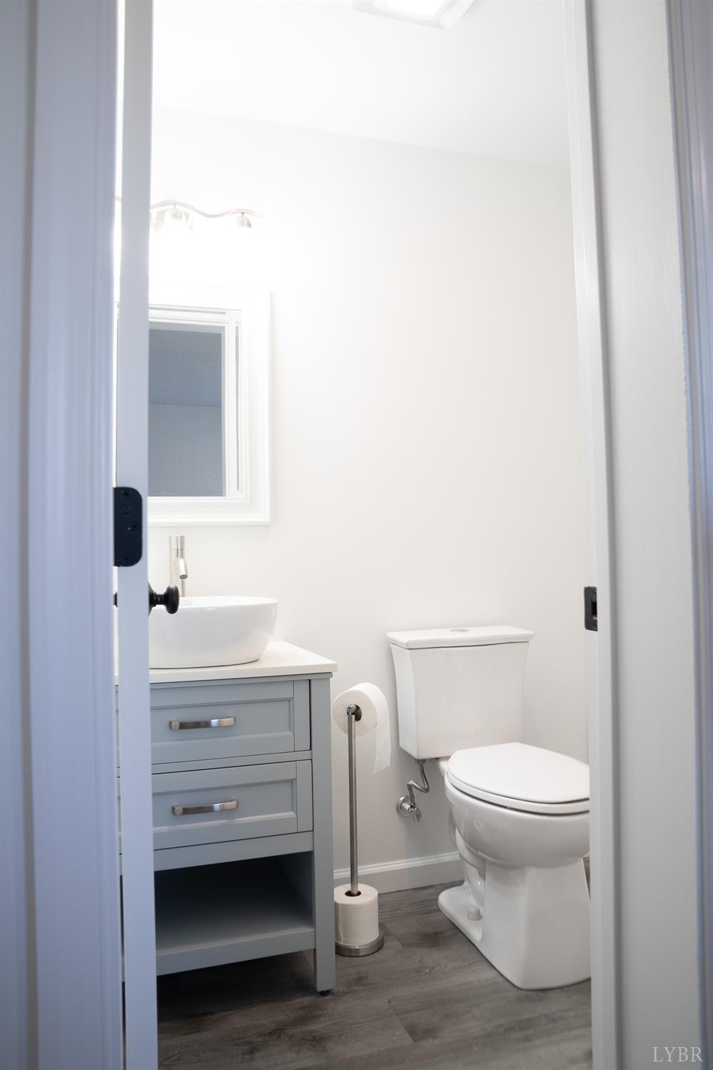 405 Spring Mill Road Concord, VA 24538 - Photo 27 of 28 a bathroom with a toilet a sink and mirror