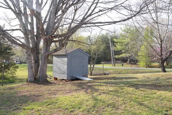 a view of a house with a yard and tree