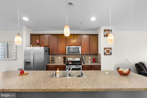 a kitchen with stainless steel appliances granite countertop a sink refrigerator and microwave