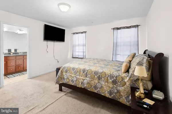 a spacious bedroom with a bed and a flat screen tv