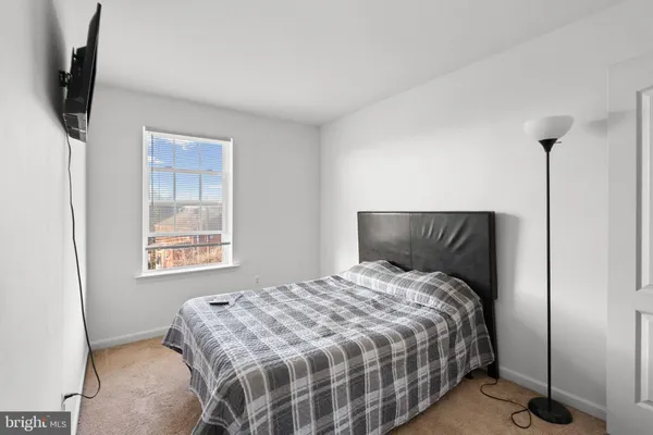 a bed sitting in a bedroom next to a window