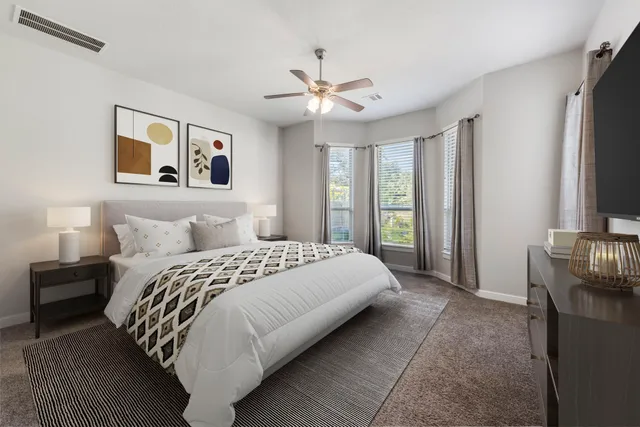 a spacious bedroom with a large bed and a chandelier