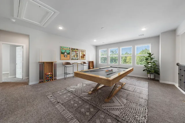 a room with furniture pool table and window