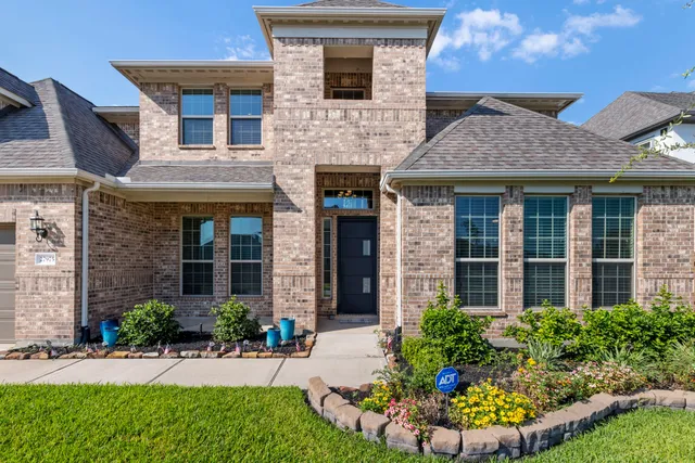front view of a brick house with a yard