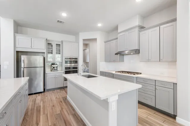 a kitchen with white cabinets and stainless steel appliances