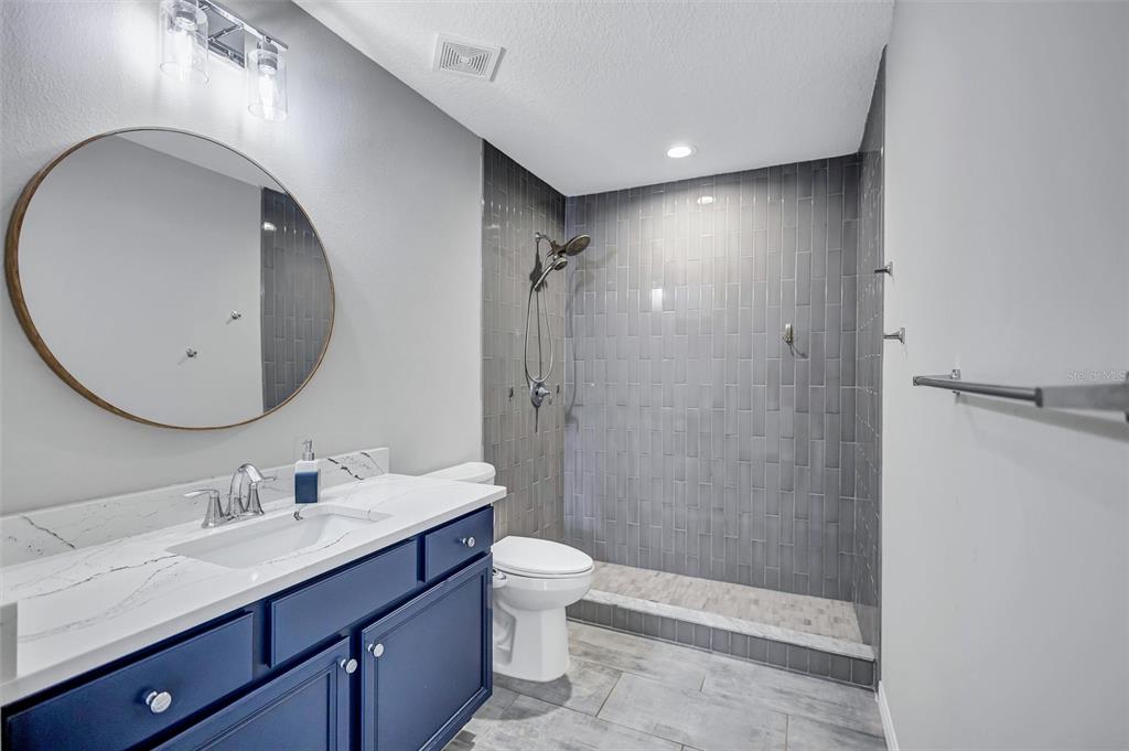 13362 Downy Woodpecker Road Weeki Wachee, FL 34614 - Photo 16 of 26 a bathroom with a double vanity sink toilet and shower