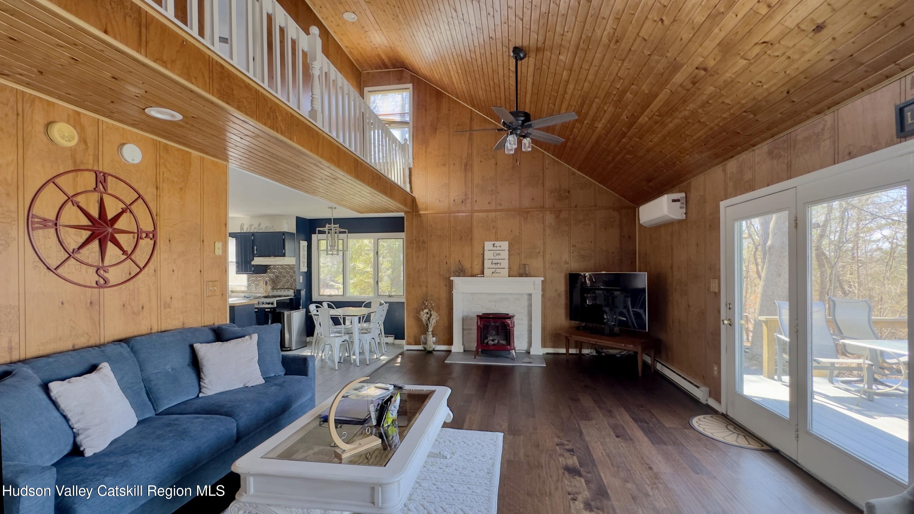 87 Sleepy Hollow Road Athens, NY 12015 - Photo 12 of 42 a living room with furniture a fireplace and a floor to ceiling window