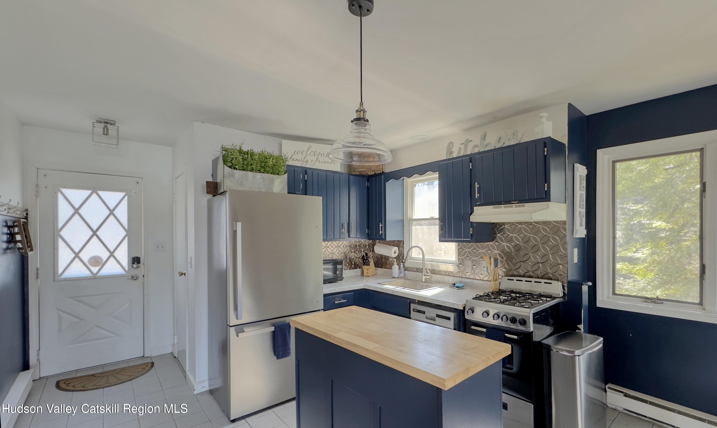 87 Sleepy Hollow Road Athens, NY 12015 - Photo 7 of 42 a kitchen with stainless steel appliances granite countertop a refrigerator a sink dishwasher a stove and a dining table with wooden floor