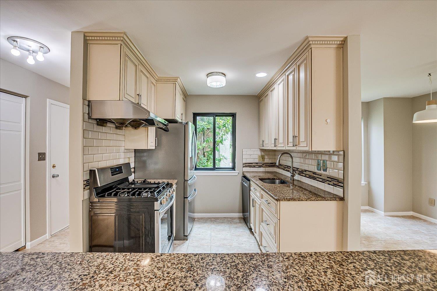83 Park Gate Drive Edison, NJ 08820 - Photo 15 of 35 a kitchen with stainless steel appliances granite countertop a stove a sink and a refrigerator
