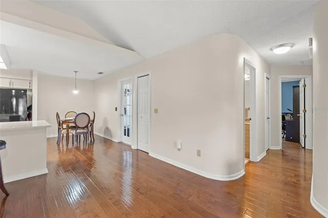 a view of a big room with wooden floor and windows