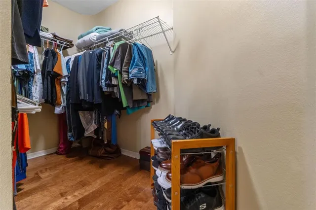 a view of walk in closet with clothes and shoes
