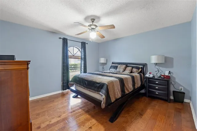 a spacious bedroom with a bed and a ceiling fan