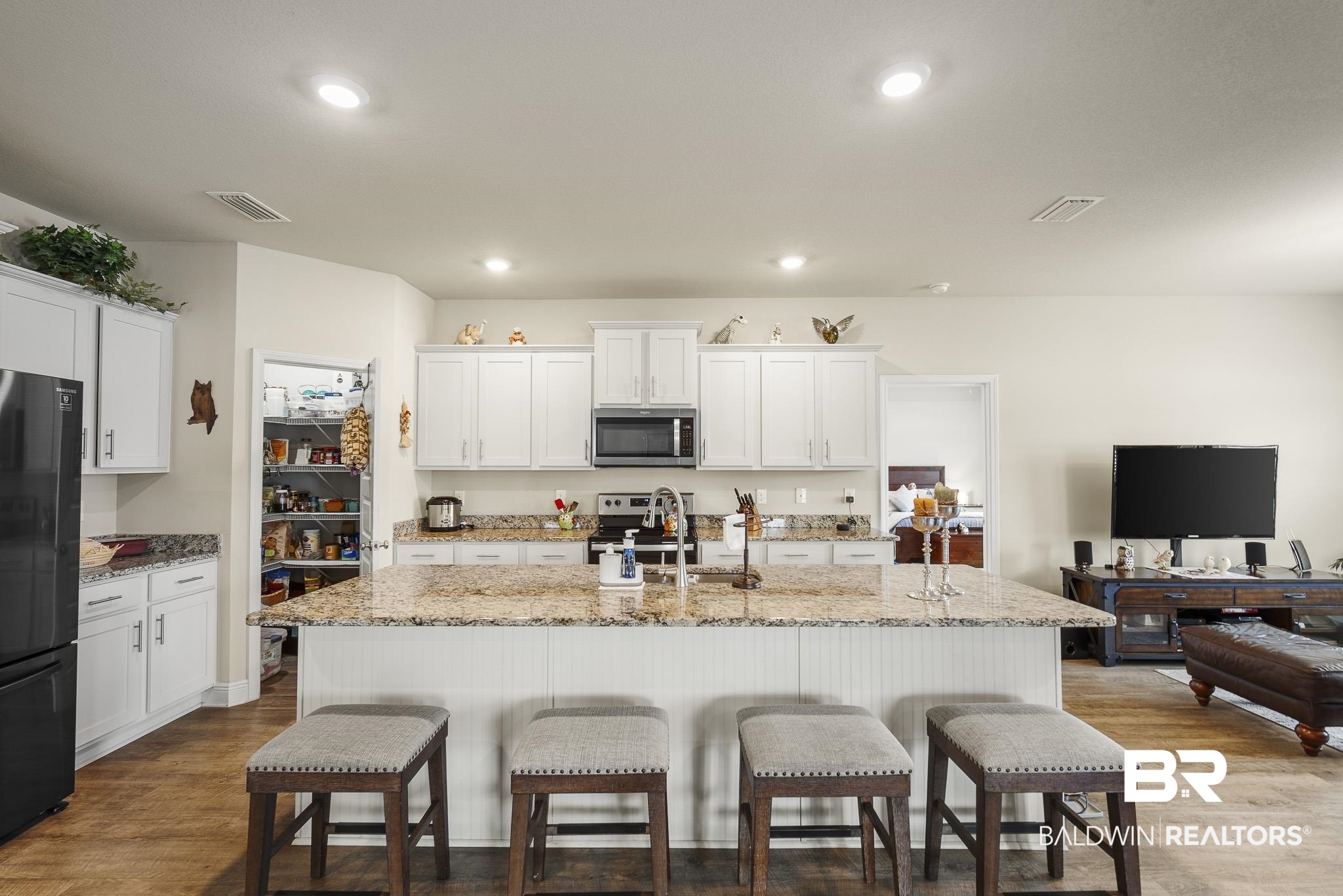 24765 Spectacular Bid Loop Daphne, AL 36526 - Photo 20 of 45 Kitchen with appliances with stainless steel finishes, an island with sink, sink, white cabinets, and light wood-type flooring