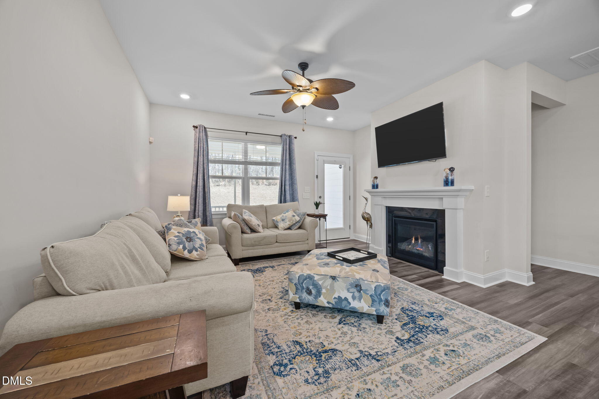 162 Desert Sand Lane Raleigh, NC 27610 - Photo 13 of 33 a living room with furniture a fireplace and a flat screen tv