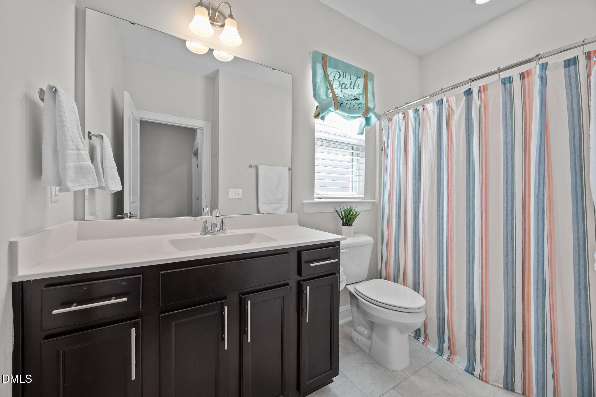 162 Desert Sand Lane Raleigh, NC 27610 - Photo 21 of 33 a bathroom with a granite countertop sink toilet a mirror and a shower