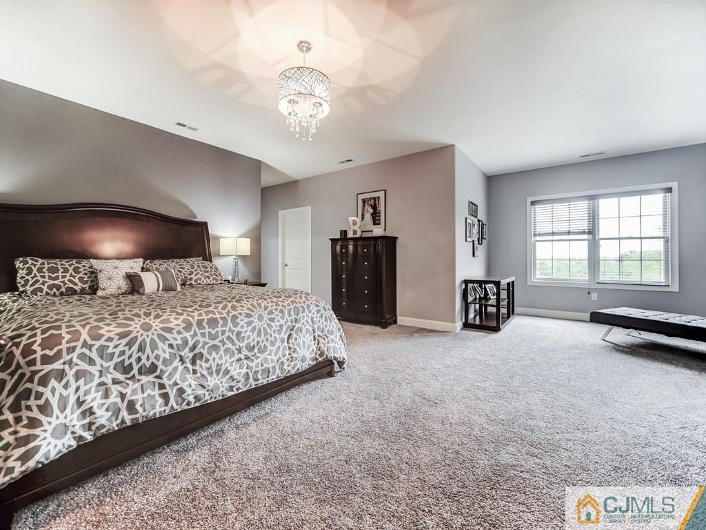 17 Thompson Grove Road Freehold, NJ 07728 - Photo 12 of 25 a bedroom with a bed and a chandelier