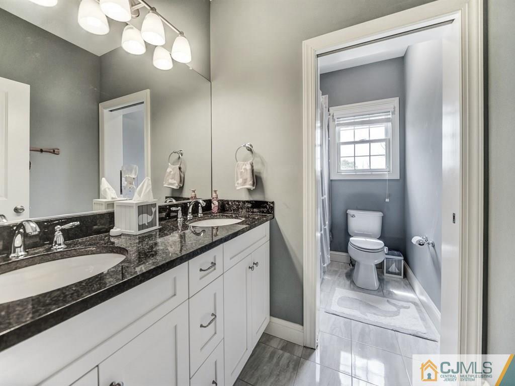17 Thompson Grove Road Freehold, NJ 07728 - Photo 18 of 25 a en suite bathroom with a granite countertop sink and a mirror