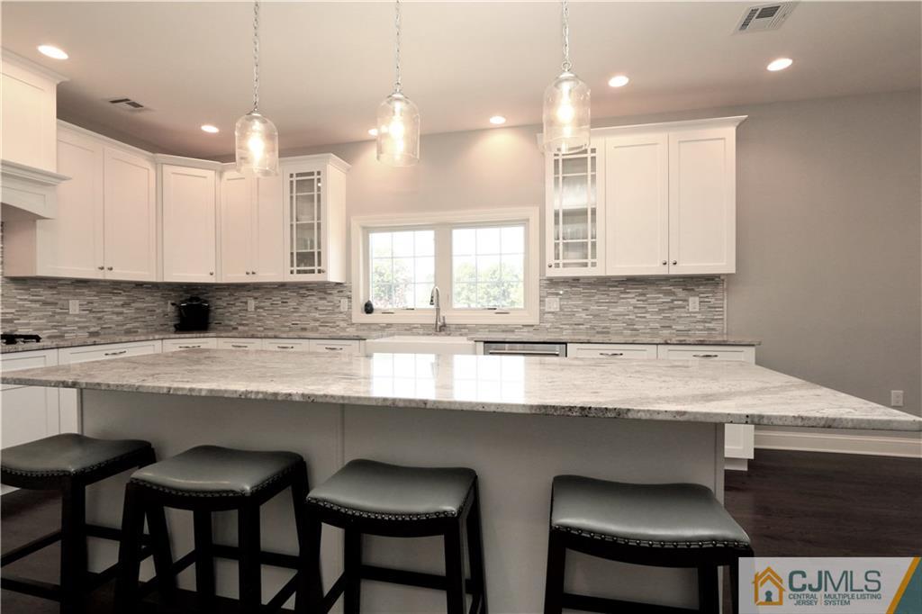 17 Thompson Grove Road Freehold, NJ 07728 - Photo 6 of 25 a kitchen with stainless steel appliances granite countertop a sink a stove a table and chairs