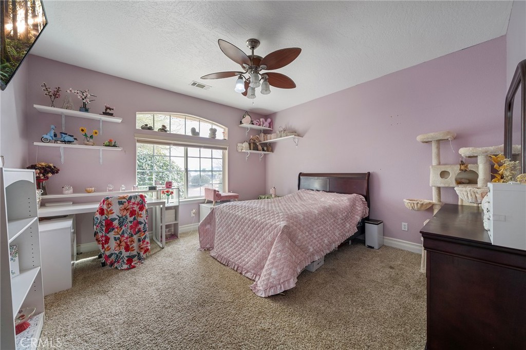 7172 Jargon Road Hesperia, CA 92344 - Photo 33 of 75 a bedroom with a bed and a chandelier