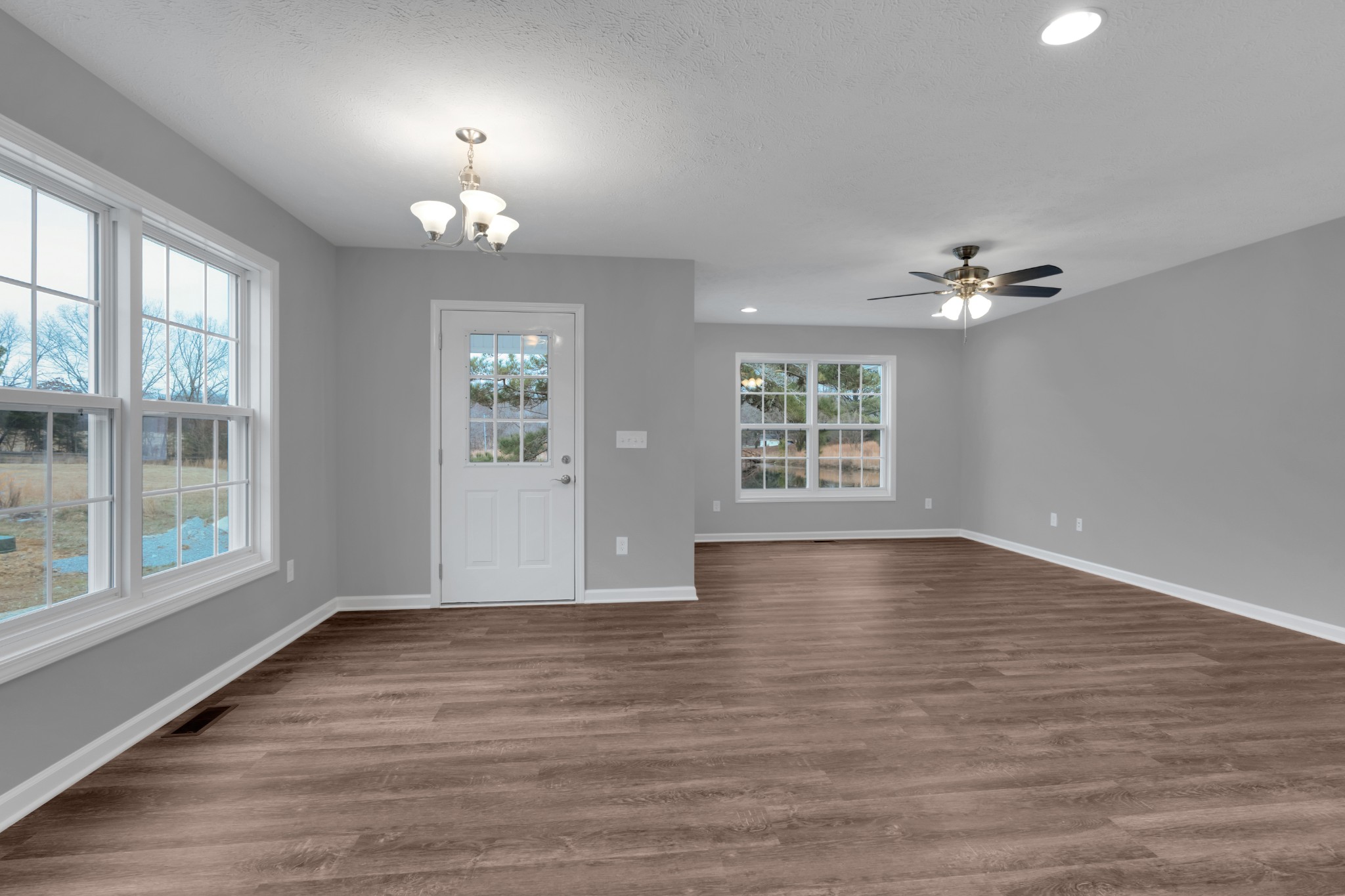 1332 Carter Blake Road Tullahoma, TN 37388 - Photo 4 of 31 an empty room with wooden floor chandelier and windows