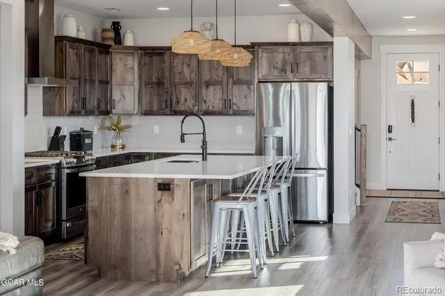 a kitchen with kitchen island a counter top space a sink stainless steel appliances and cabinets