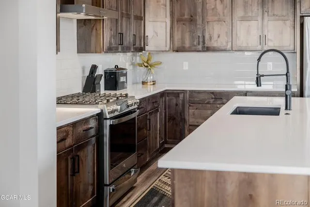 a kitchen with stainless steel appliances a stove a sink and a microwave