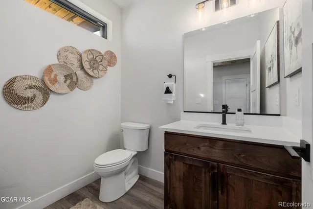 a bathroom with a granite countertop toilet sink and mirror