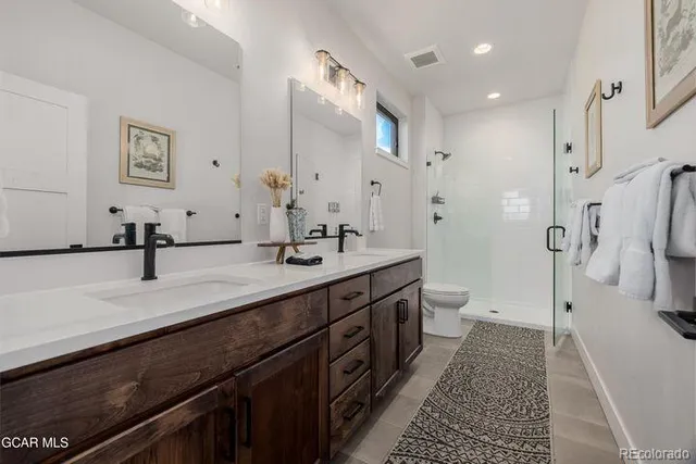 a spacious bathroom with a double vanity sink mirror double and shower