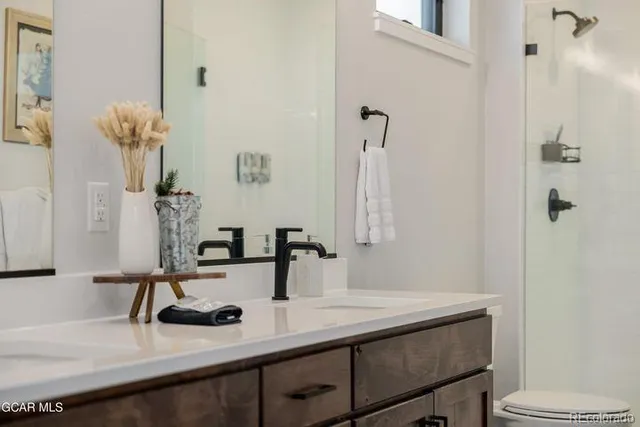 a bathroom with a sink and a mirror with toilet