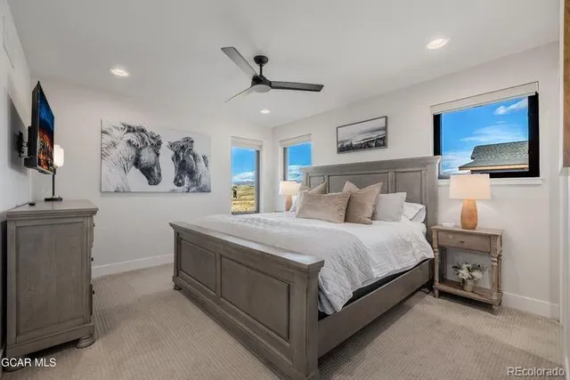 a spacious bedroom with a bed and a tv