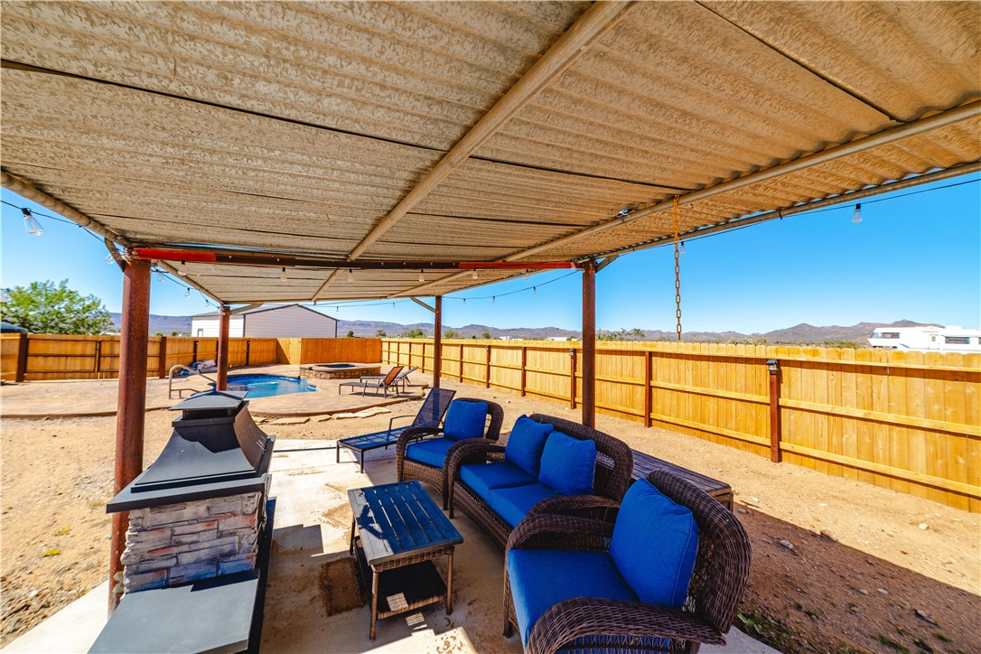 4938 Davis Road Golden Valley, AZ 86413 - Photo 54 of 90 Fenced backyard featuring an outdoor living space, a patio area, a mountain view, and a pool with connected hot tub